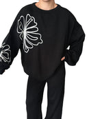 Tvådelad kostym med vida byxor och blommönster på blusen