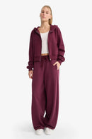 Brun träningsoverall med utsvängda byxor och dragkedja på blusen