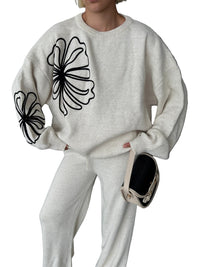 Tvådelad kostym med vida byxor och blommönster på blusen