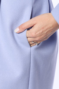 Lång ljusblå kappa med två rader knappar