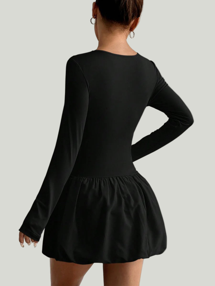 Svart klänning från Lorra med långa ärmar och rynkad nederdel