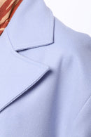 Lång ljusblå kappa med två rader knappar