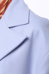 Lång ljusblå kappa med två rader knappar