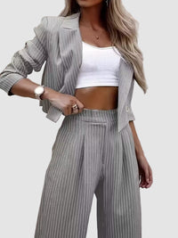 Elegant vitrandig kostym med kavaj och utsvängda byxor