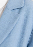 Blå kappa med långa ärmar, knälång och knappar