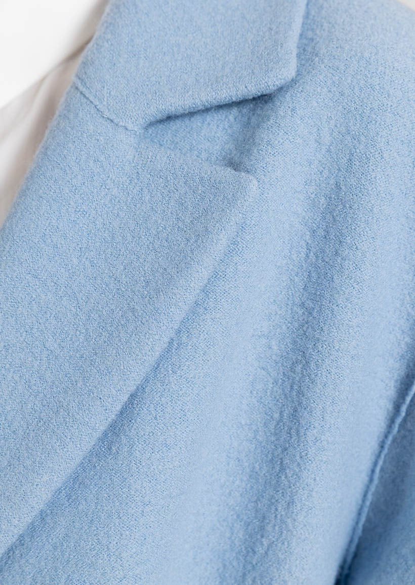 Blå kappa med långa ärmar, knälång och knappar