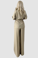 Tvådelad kostym med utsvängda byxor och blus med knappar