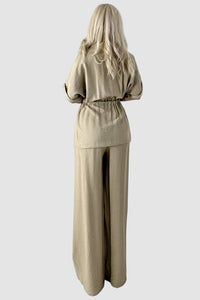 Tvådelad kostym med utsvängda byxor och blus med knappar