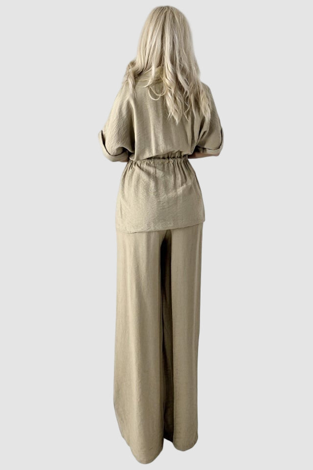 Tvådelad kostym med utsvängda byxor och blus med knappar