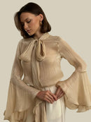 Beige skjorta med långa utsvängda ärmar och rosett i halsen