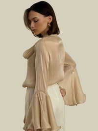 Beige skjorta med långa utsvängda ärmar och rosett i halsen