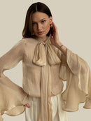 Beige skjorta med långa utsvängda ärmar och rosett i halsen