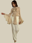 Beige skjorta med långa utsvängda ärmar och rosett i halsen