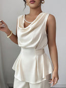 Vit kostym med blus med vågor i ändarna och utsvängda byxor