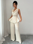 Vit kostym med blus med vågor i ändarna och utsvängda byxor