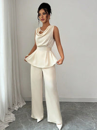 Vit kostym med blus med vågor i ändarna och utsvängda byxor