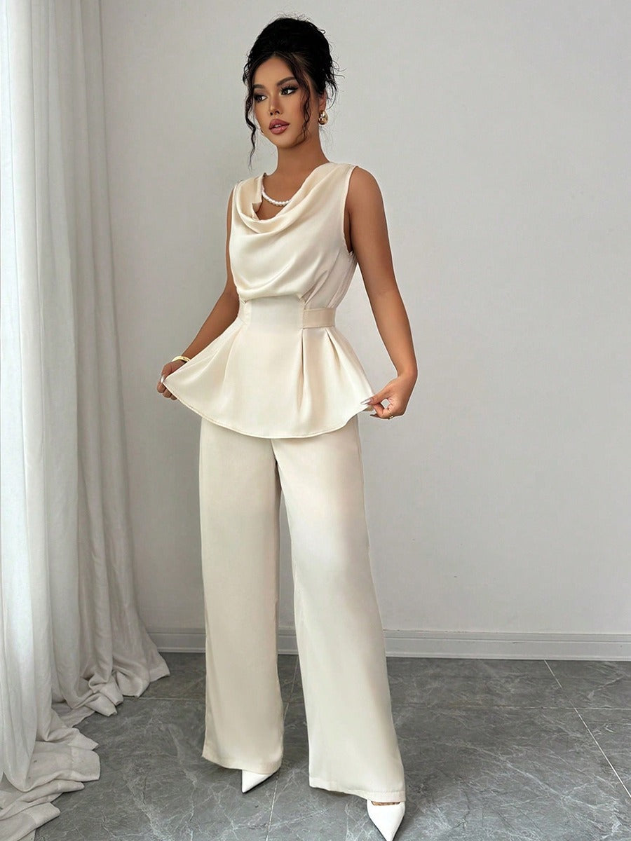 Vit kostym med blus med vågor i ändarna och utsvängda byxor