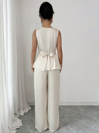 Vit kostym med blus med vågor i ändarna och utsvängda byxor