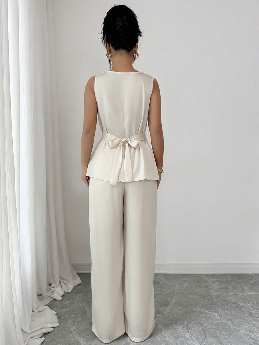 Vit kostym med blus med vågor i ändarna och utsvängda byxor