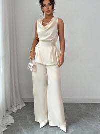 Vit kostym med blus med vågor i ändarna och utsvängda byxor