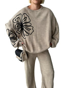 Tvådelad kostym med vida byxor och blommönster på blusen