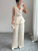 Vit kostym med blus med vågor i ändarna och utsvängda byxor