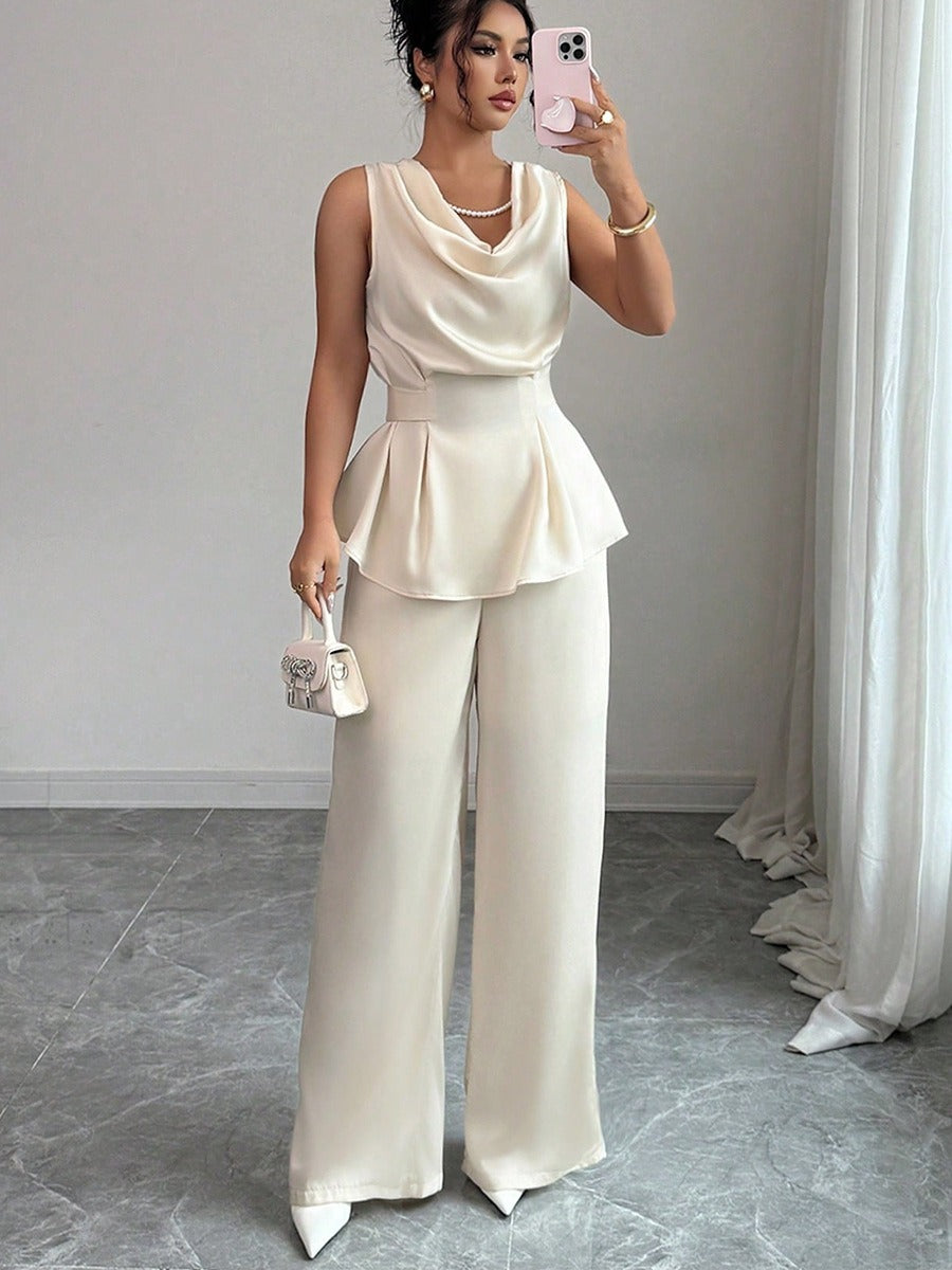 Vit kostym med blus med vågor i ändarna och utsvängda byxor