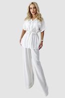 Tvådelad kostym med utsvängda byxor och blus med knappar