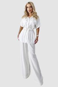 Tvådelad kostym med utsvängda byxor och blus med knappar