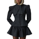 Grått tvådelat set med kjol, långa ärmar och fluga