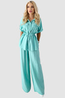 Tvådelad kostym med utsvängda byxor och blus med knappar