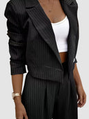 Elegant vitrandig kostym med kavaj och utsvängda byxor